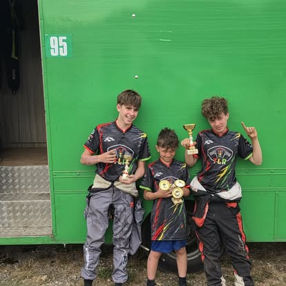 The boys celebrating with trophies in the paddock